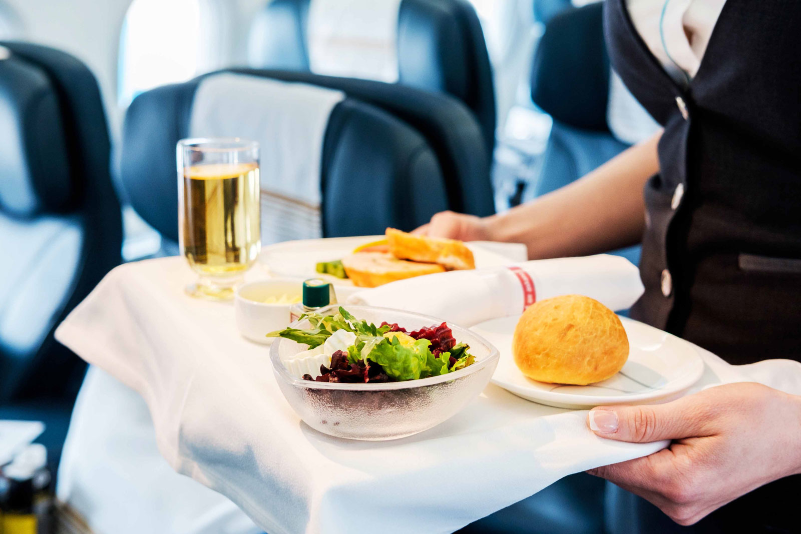 Flugbegleiterin serviert Esssen auf einem Tablett 